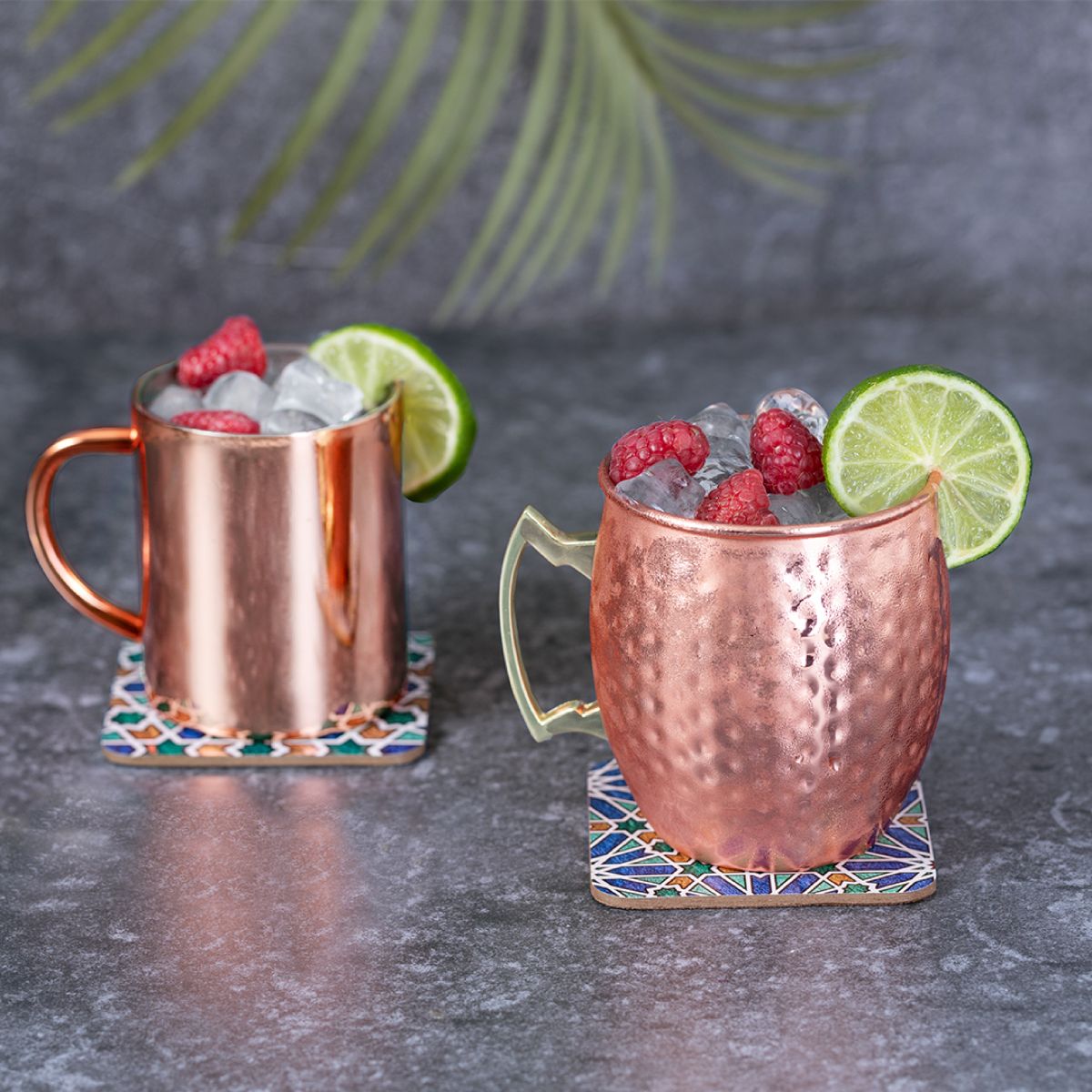 Moscow Mule Becher 50 cl aus gehämmertem Edelstahl mit Logo, gefüllter Drink in stimmungsvoller Barumgebung