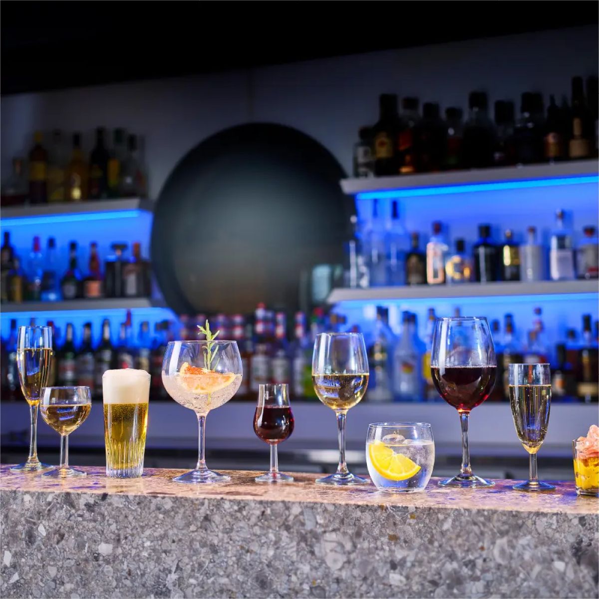 Gefülltes Cosy Moments Glas 34 cl. mit aufgedrucktem Logo in stimmungsvollem Rahmen auf der Bar.