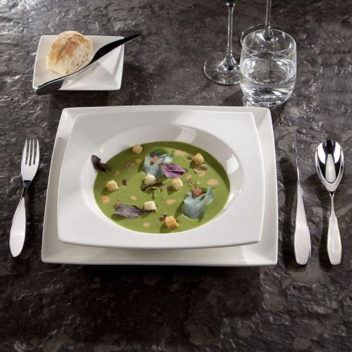 Teller Quadratisch Squito 23 cm aus Porzellan mit Füllung, platziert in einem Stimmungsraum.