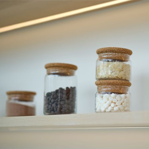 Glass mit Deckel 1 Liter mit Füllung und Logo, der in einem Innenraum verwendet wird.