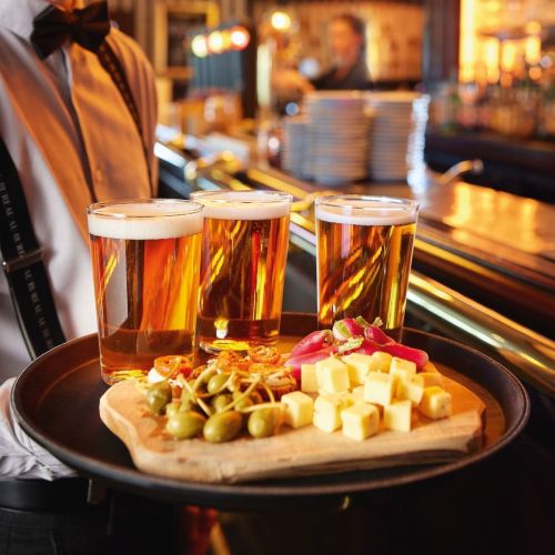 Gefülltes Glas Conique 47 cl. mit Logo, platziert in einer stimmungsvollen Umgebung mit warmer Beleuchtung. Gefülltes Glas Conique 47 cl. mit Logo, platziert in einer stimmungsvollen Umgebung mit warmer Beleuchtung.