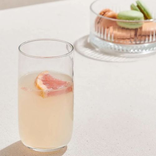 Atmosphärischer Rahmen mit einem gefüllten Glas Iconic Tumbler 36,5 cl. mit sichtbarem Logo auf der Oberfläche.