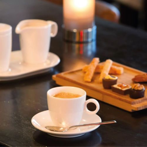 Bart Espressotasse aus Porzellan, gefüllt mit Kaffee, stimmungsvoll in Szene gesetzt. Bart Espressotasse aus Porzellan, gefüllt mit Kaffee, stimmungsvoll in Szene gesetzt.