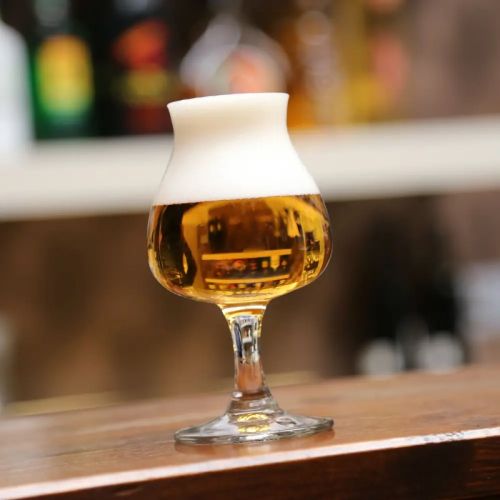Gefülltes Bierglas Specials Tasting 25 cl. in stimmungsvollem Rahmen, platziert auf Holztisch. Gefülltes Bierglas Specials Tasting 25 cl. in stimmungsvollem Rahmen, platziert auf Holztisch.