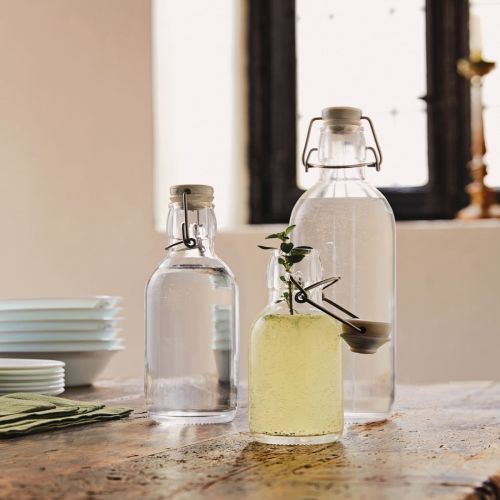 Emilia-Flasche 0,5 Liter mit Logo auf dem Tisch in einer warm beleuchteten Umgebung.