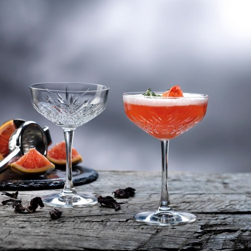 Timeless Champagner Coupe 25,5 cl. mit Getränkefüllung, attraktiv präsentiert in einem stimmungsvollen Rahmen.