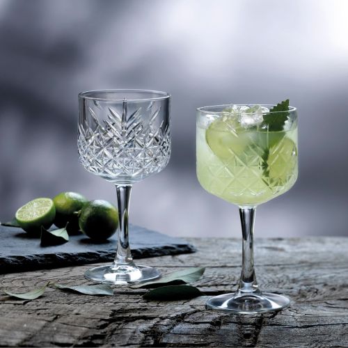 Gefülltes Timeless Gin-Tonic-Glas 55 cl. in stimmungsvollem Rahmen auf dem Tisch präsentiert. Gefülltes Timeless Gin-Tonic-Glas 55 cl. in stimmungsvollem Rahmen auf dem Tisch präsentiert.