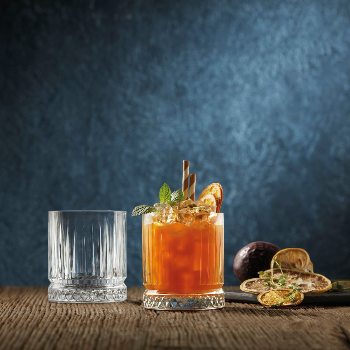Elysia Whiskyglas 21 cl. gefüllt mit Likör in einem stimmungsvollen Raum präsentiert.