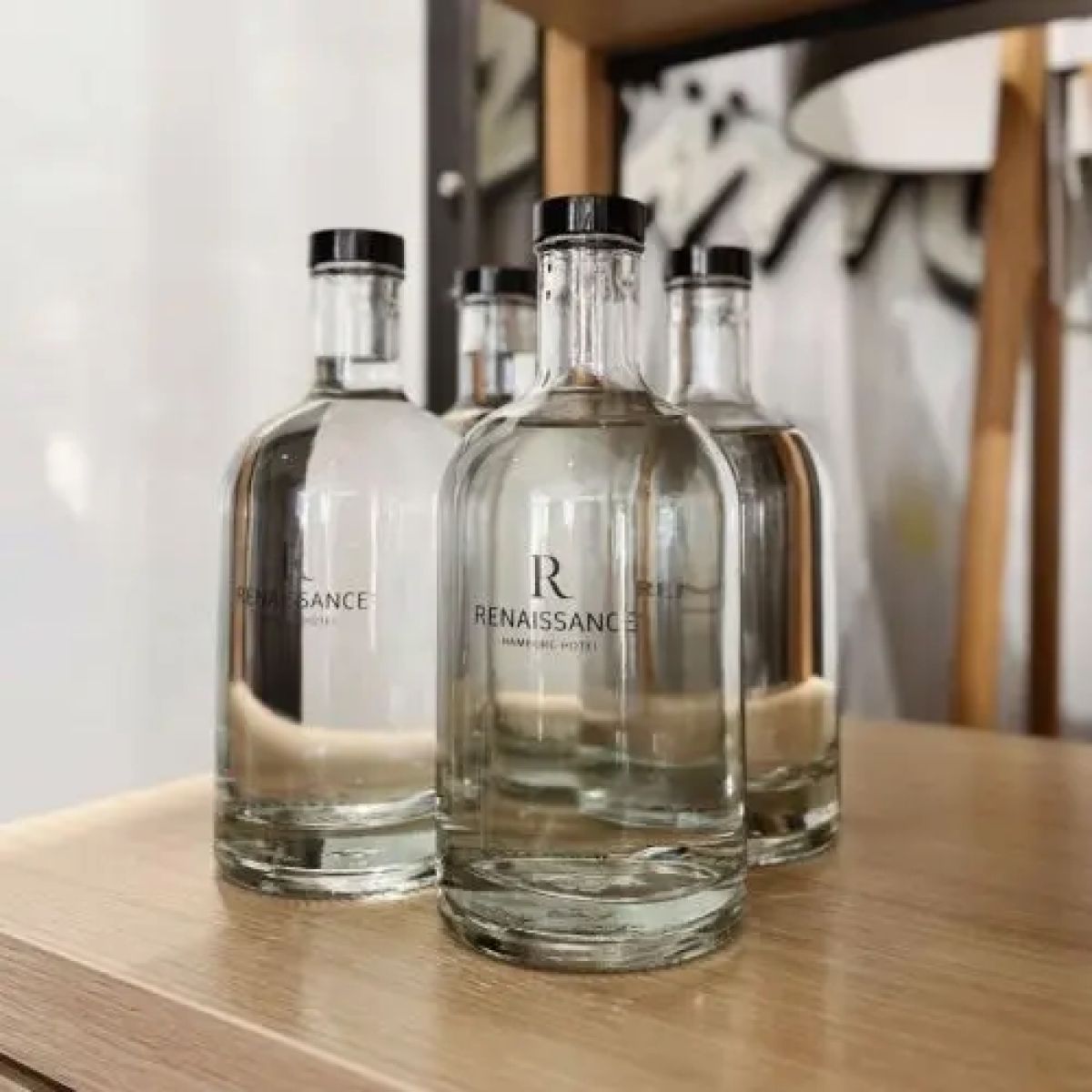 Gefüllte Flasche Oslo 0,7 Liter mit aufgedrucktem Logo in einem dekorierten Ambiente-Raum.